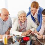 Happy family with senior couple playing parlor games